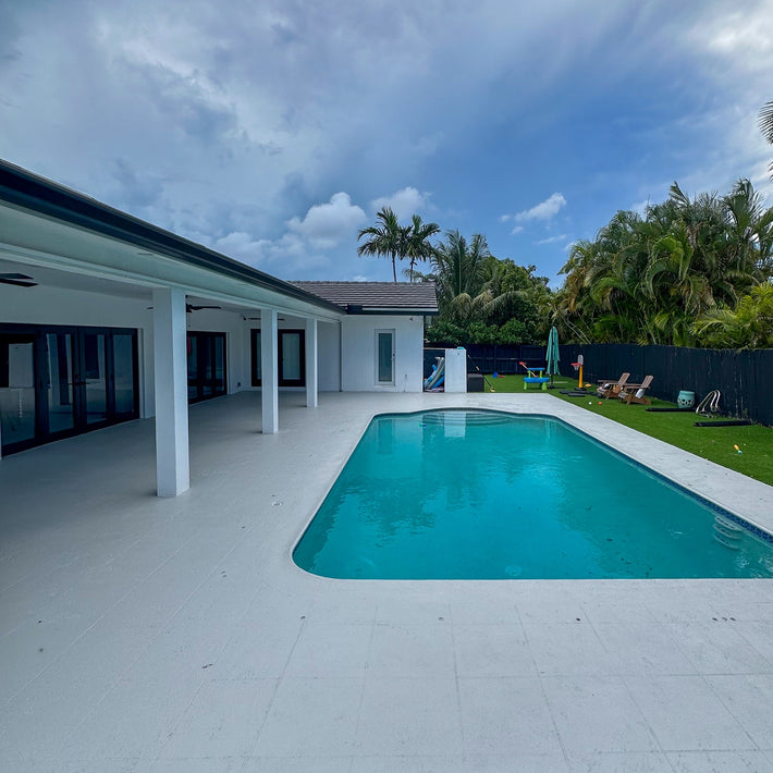 Smooth plain concrete pool deck installed for durability and slip resistance in Miami