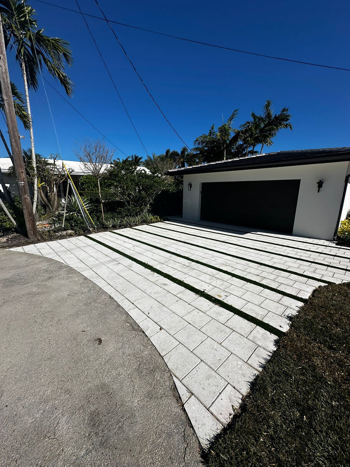 Artificial turf installed between pavers to create a modern driveway in Miami